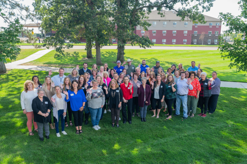 50 clerks pose for a group shot on the lawn of the Sourcewell campus in Staples..